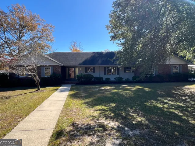 a view of house with yard swimming pool and a patio