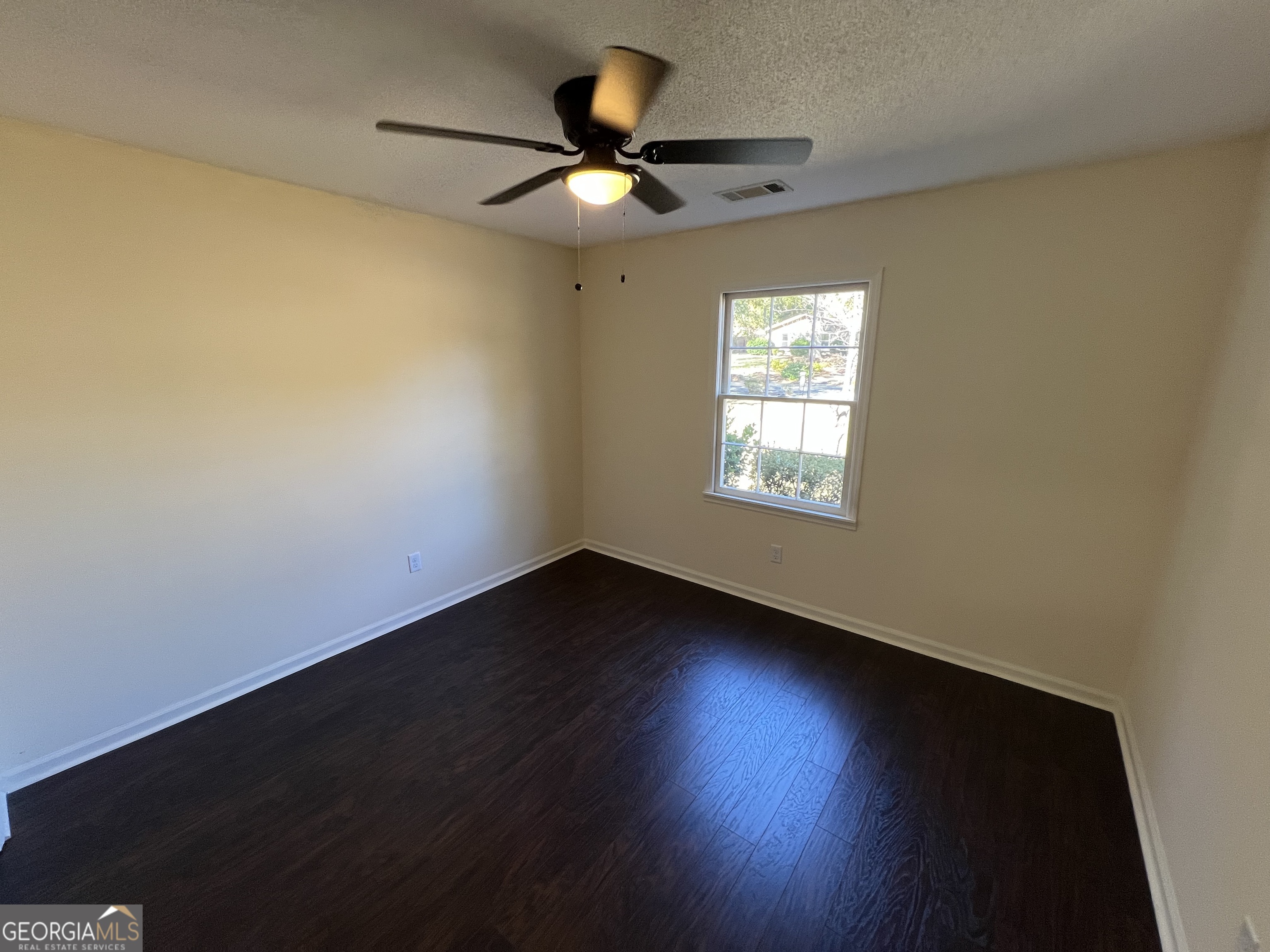 311 Fairmont Road Dublin, GA 31021 - Photo 15 of 33 a view of an empty room with wooden floor and a window