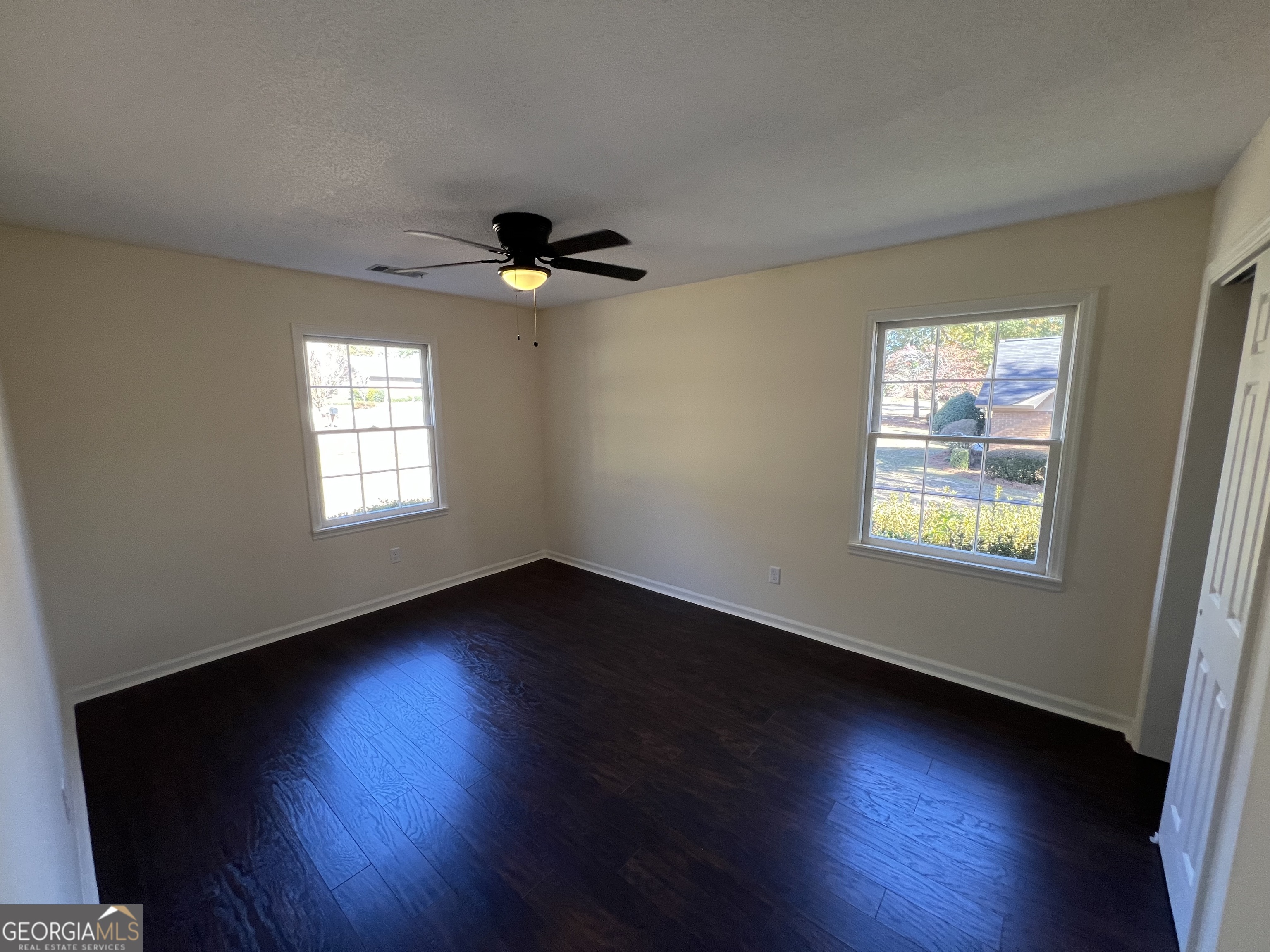 311 Fairmont Road Dublin, GA 31021 - Photo 16 of 33 an empty room with wooden floor and windows