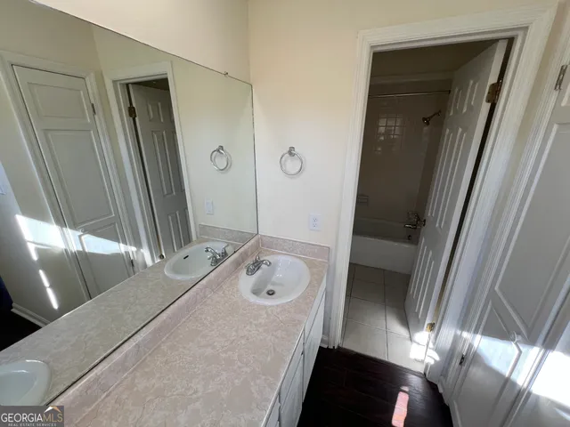 a bathroom with a tub sink and mirror