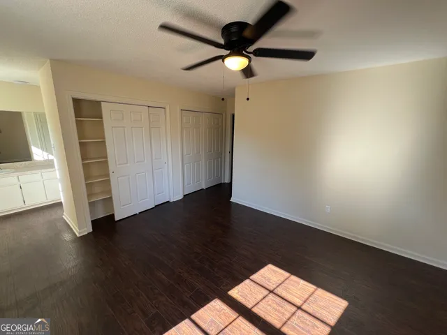 a view of a livingroom with wooden floor and a ceiling fan