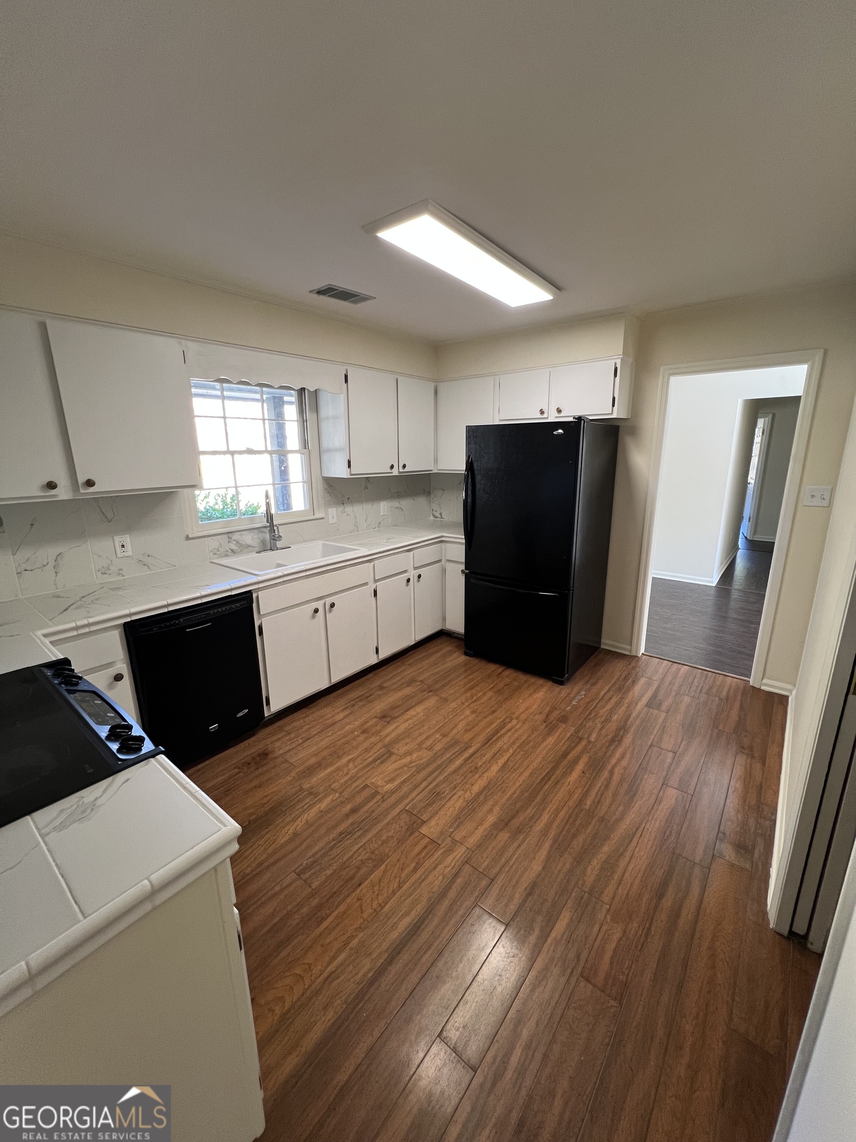 311 Fairmont Road Dublin, GA 31021 - Photo 4 of 33 a kitchen with granite countertop a refrigerator a sink dishwasher and wooden cabinets