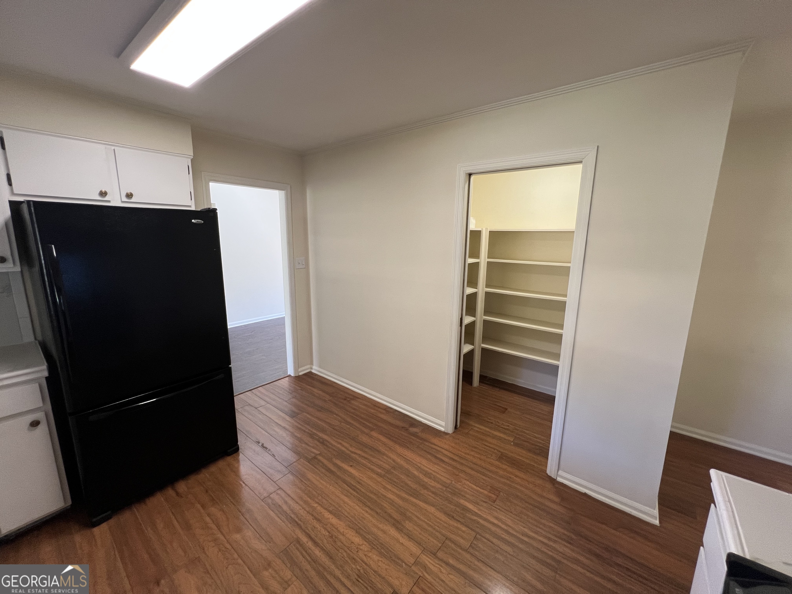 311 Fairmont Road Dublin, GA 31021 - Photo 6 of 33 a view of a kitchen with wooden floor and a refrigerator