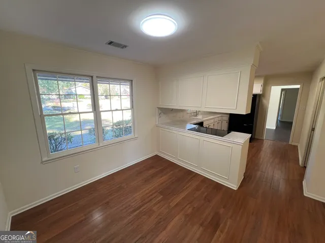 a living room with wooden floor and a window