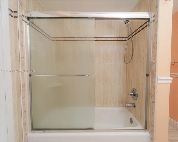 a bathroom with a shower and a glass door
