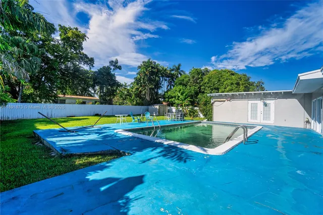 a view of yard with swimming pool and green space