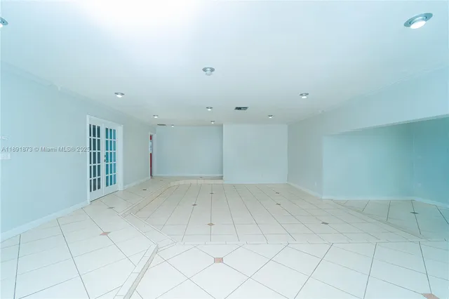 an empty room with white walls and tiles