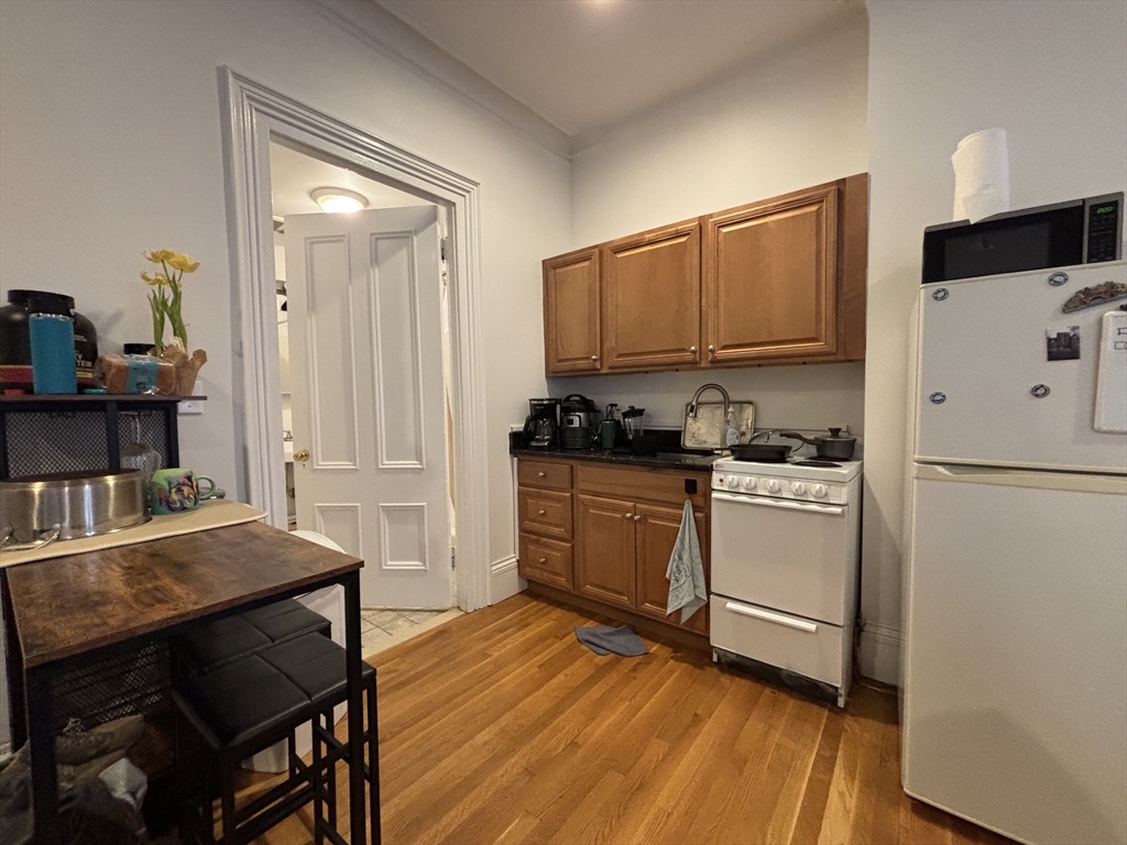 98 Charles Street, Unit 1 Boston, MA 02114 - Photo 5 of 9 a kitchen with a refrigerator and a stove top oven