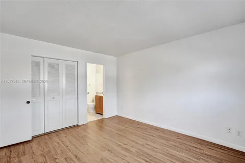 a view of a room with wooden floor and white doors