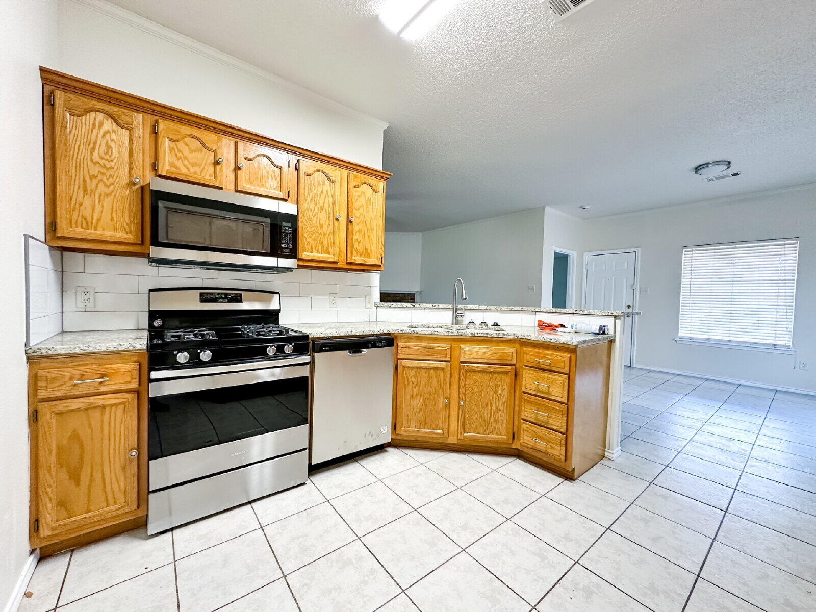 10622 Boston Avenue Lubbock, TX 79423 - Photo 13 of 28 a kitchen with stainless steel appliances granite countertop a stove and a microwave