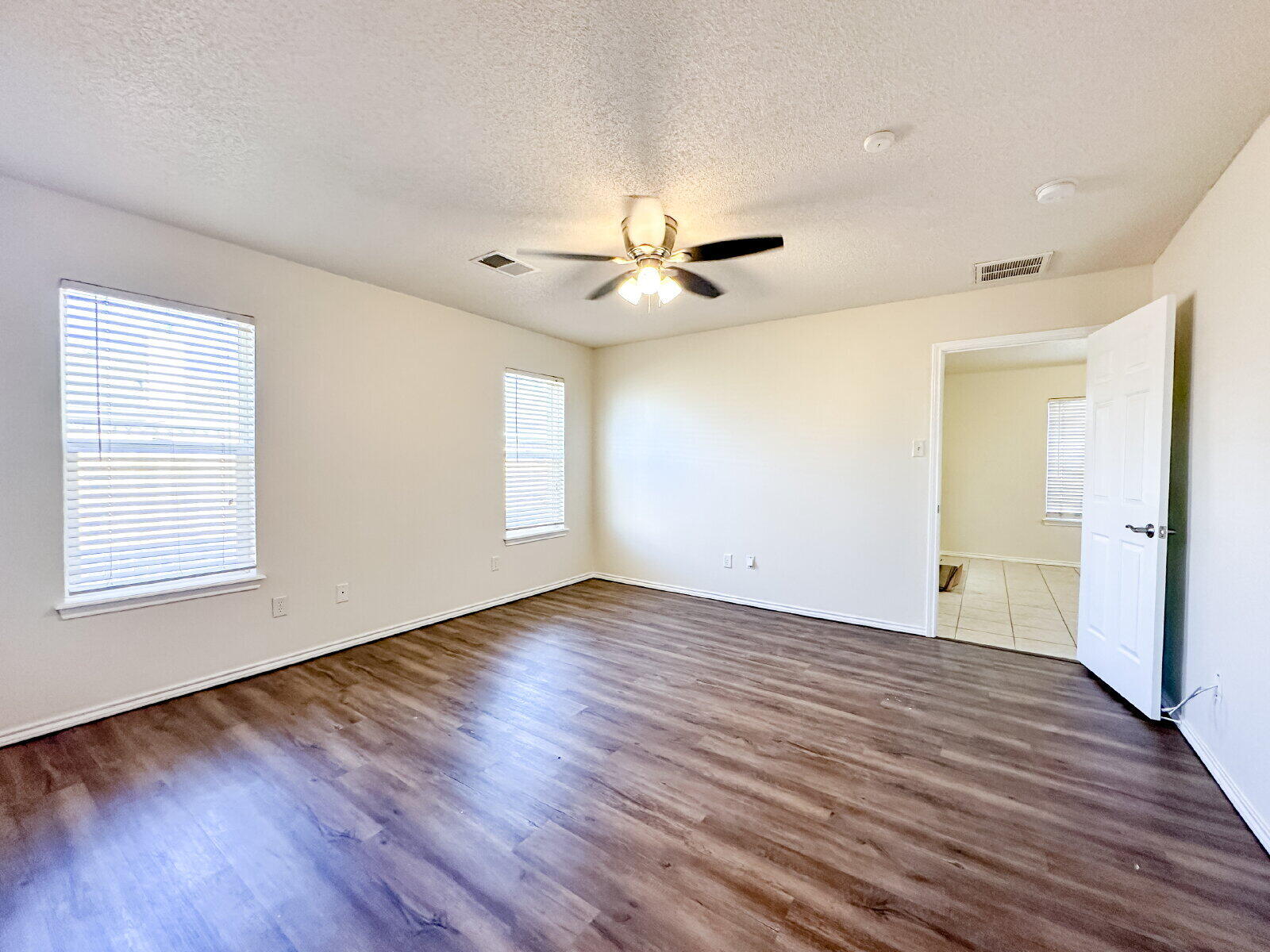 10622 Boston Avenue Lubbock, TX 79423 - Photo 14 of 28 a view of an empty room with wooden floor and a window