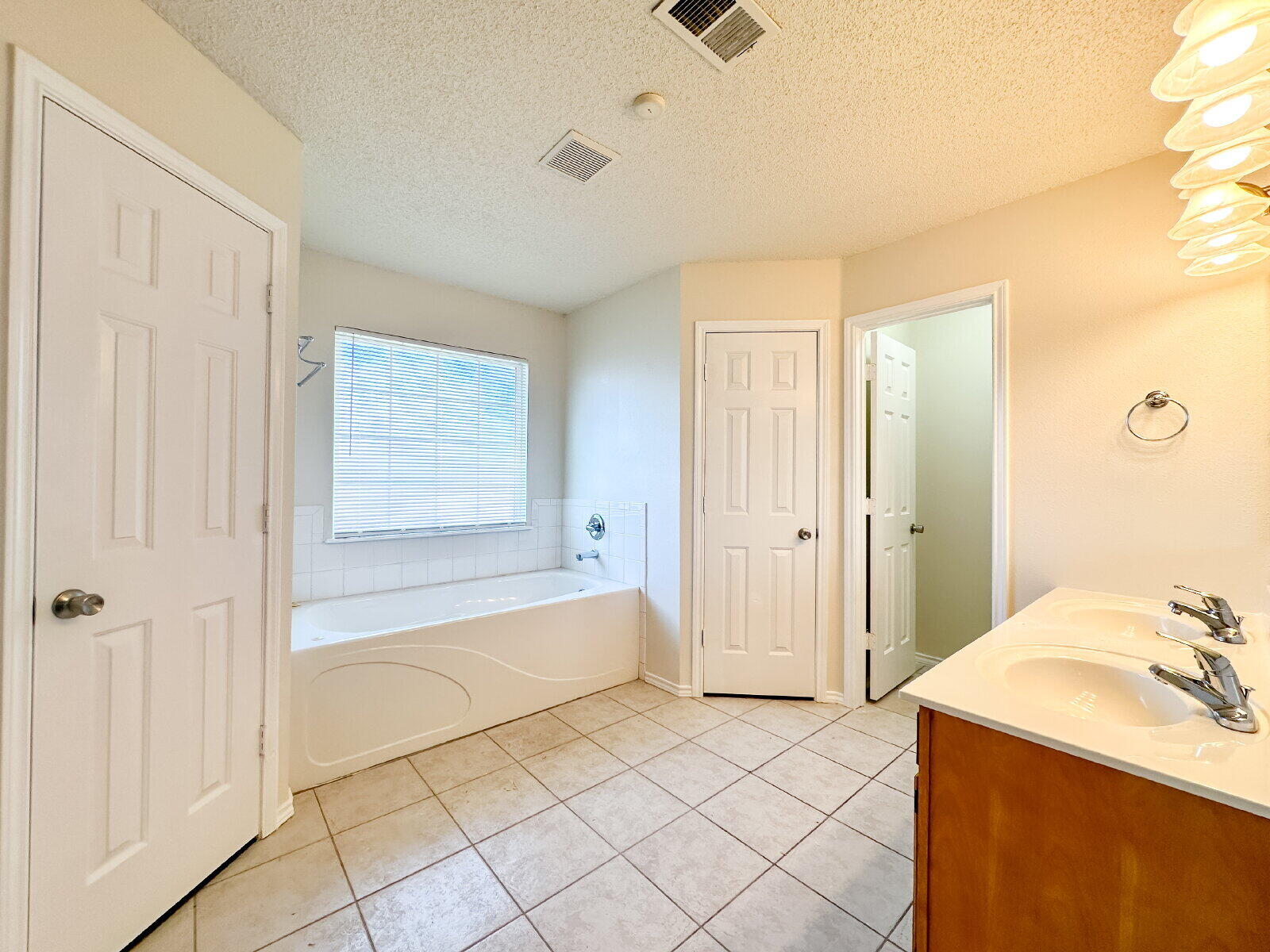 10622 Boston Avenue Lubbock, TX 79423 - Photo 18 of 28 a spacious bathroom with a granite countertop sink a mirror and a bathtub