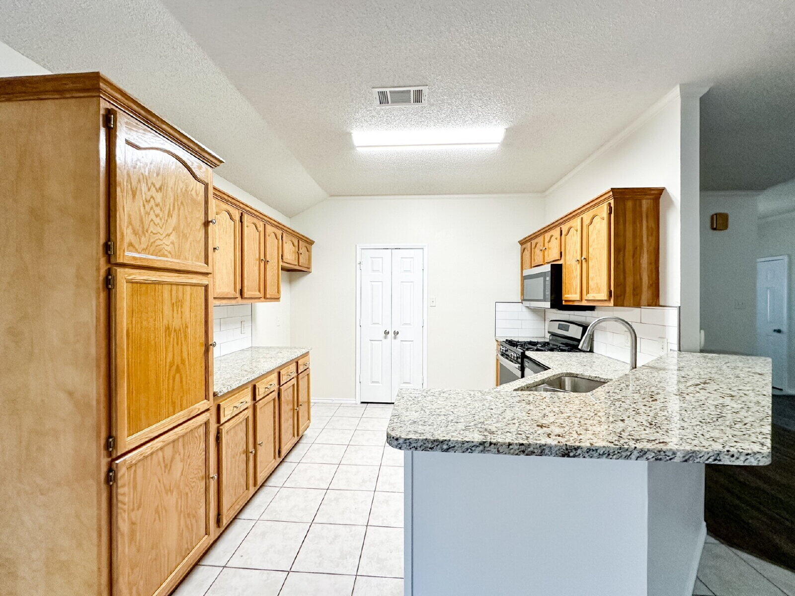 10622 Boston Avenue Lubbock, TX 79423 - Photo 9 of 28 a kitchen with granite countertop a sink and a refrigerator