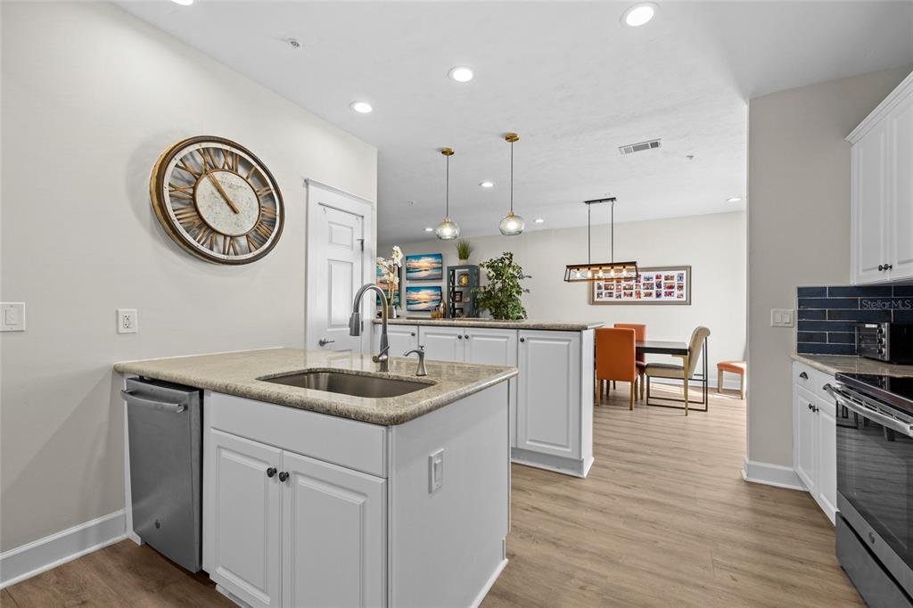 127 Northeast 3rd Street Gainesville, FL 32601 - Photo 12 of 30 a kitchen with kitchen island granite countertop a sink a stove and a wooden floors