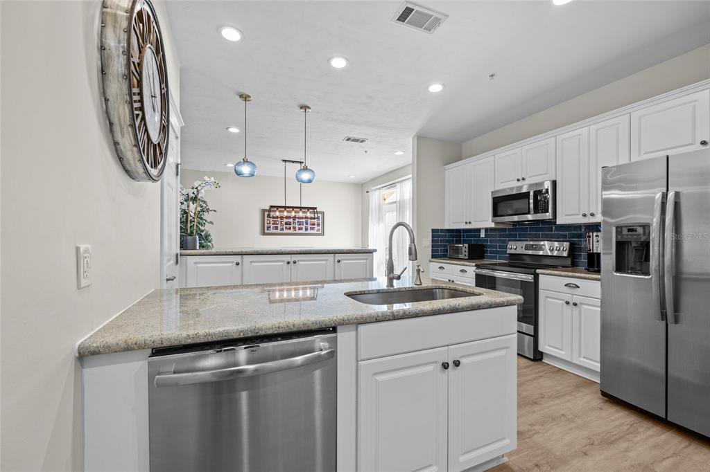 127 Northeast 3rd Street Gainesville, FL 32601 - Photo 13 of 30 a kitchen with granite countertop a sink stainless steel appliances a counter space and cabinets