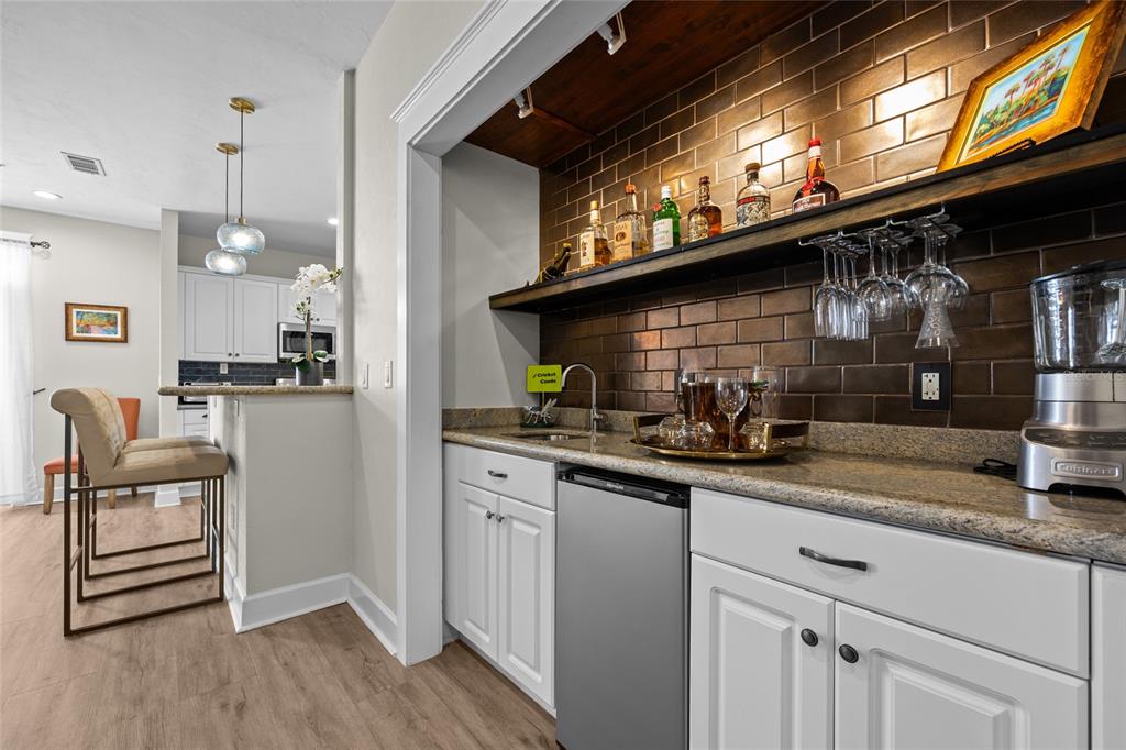 127 Northeast 3rd Street Gainesville, FL 32601 - Photo 7 of 30 a kitchen with stainless steel appliances granite countertop a sink a stove and a wooden floors