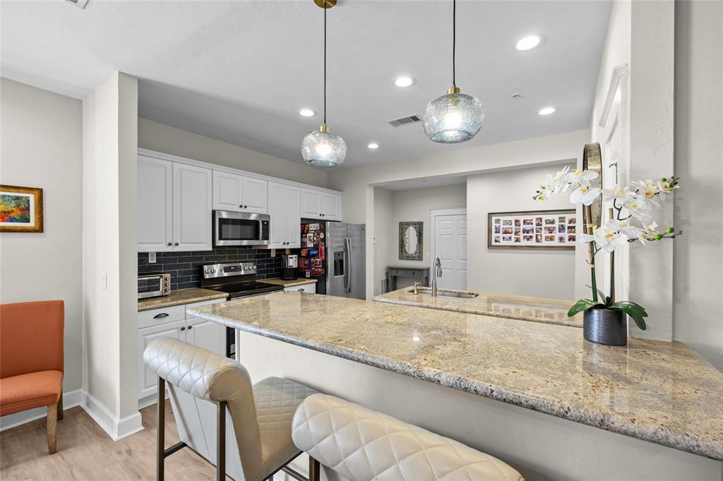 127 Northeast 3rd Street Gainesville, FL 32601 - Photo 10 of 30 a kitchen with stainless steel appliances granite countertop a sink and a refrigerator
