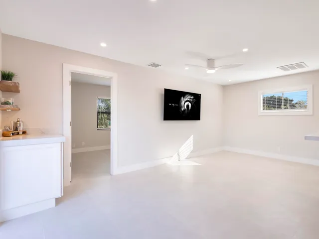 a view of a backyard with potted plants and large trees