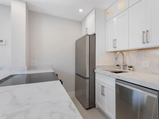 a view of kitchen with kitchen island and stainless steel appliances