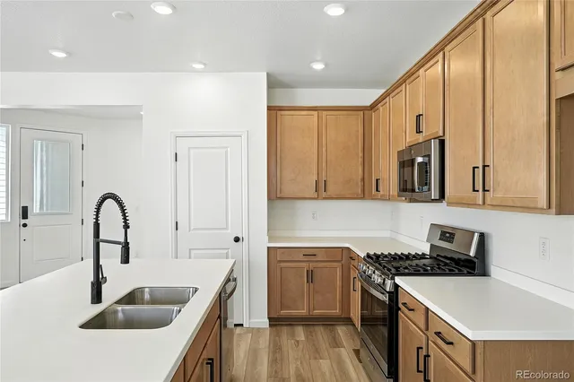 a kitchen with granite countertop a sink a stove and refrigerator