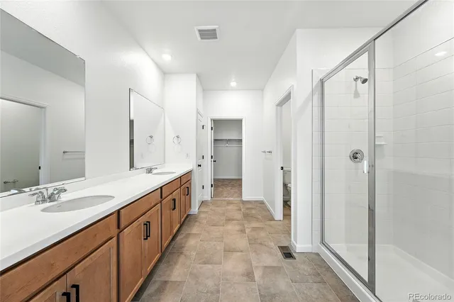 a spacious bathroom with a double vanity sink mirror double and shower