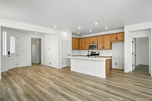 a kitchen with stainless steel appliances granite countertop a refrigerator and a stove top oven