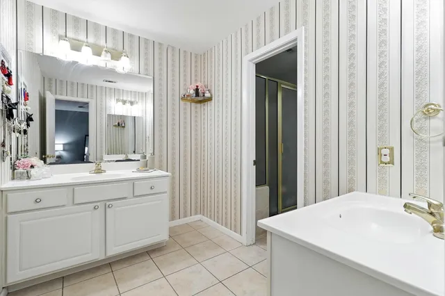 a spacious bathroom with a sink and a mirror