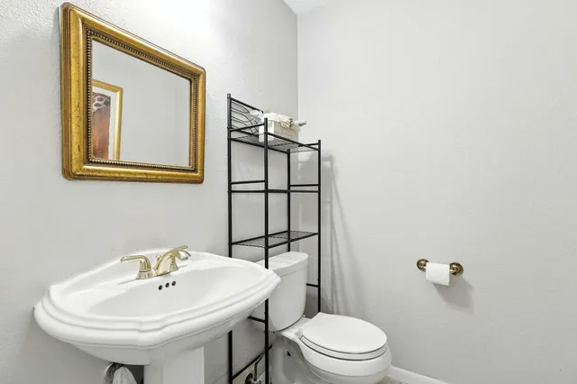 a bathroom with a sink a toilet and mirror