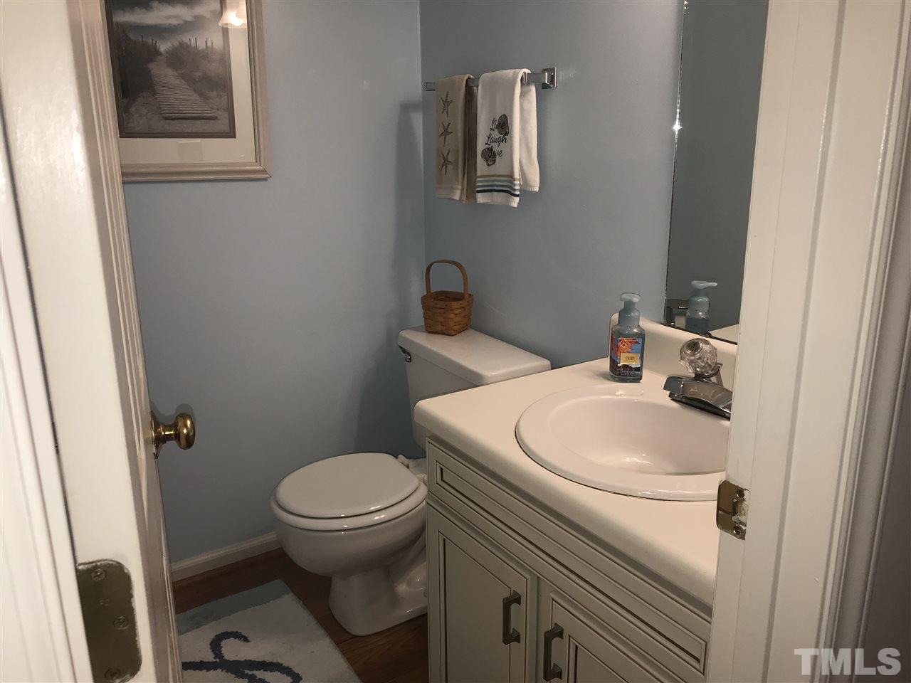 4740 Worcester Place Raleigh, NC 27604 - Photo 12 of 25 a white toilet sitting next to a white sink and vanity