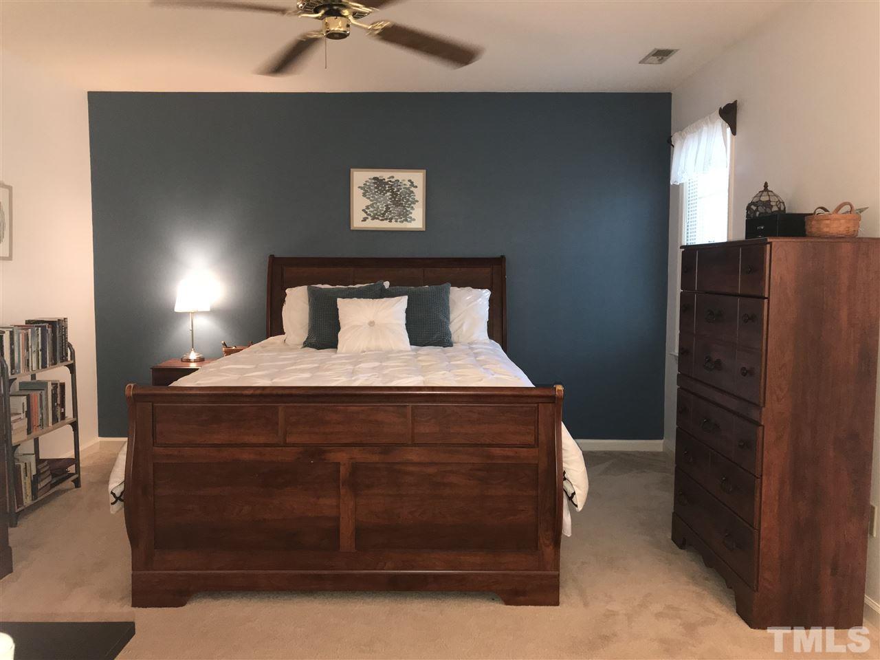 4740 Worcester Place Raleigh, NC 27604 - Photo 14 of 25 a bedroom with a bed and a ceiling fan