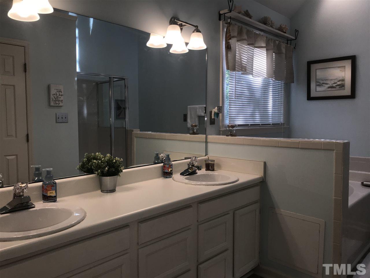 4740 Worcester Place Raleigh, NC 27604 - Photo 16 of 25 a bathroom with double vanity sinks a vanity and a mirror