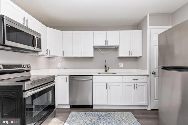 a kitchen with stainless steel appliances granite countertop a sink stove and microwave