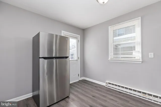 a view of empty room with wooden floor and window