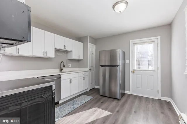 a kitchen with a refrigerator sink and cabinets