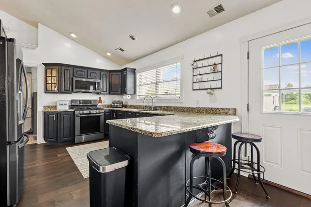 a kitchen with stainless steel appliances granite countertop a stove and a refrigerator