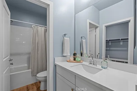 a bathroom with a double vanity sink toilet mirror and bathtub