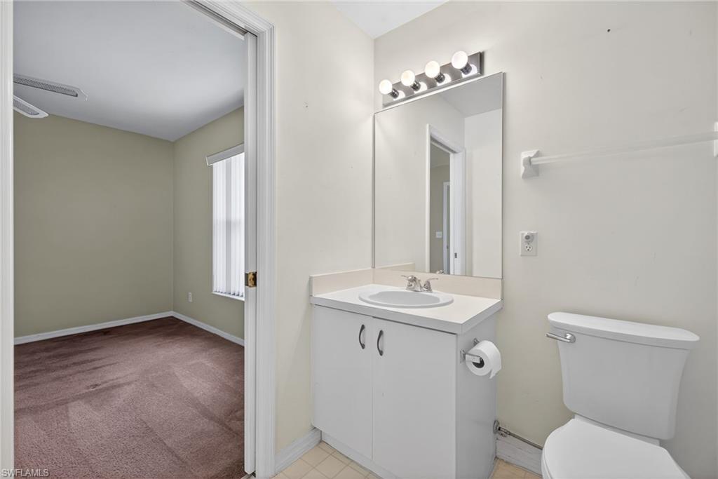 6316 Shadowood Circle Naples, FL 34112 - Photo 14 of 26 a bathroom with a toilet sink and mirror