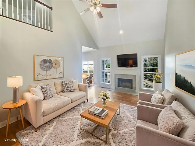 a living room with furniture a fireplace and a flat screen tv
