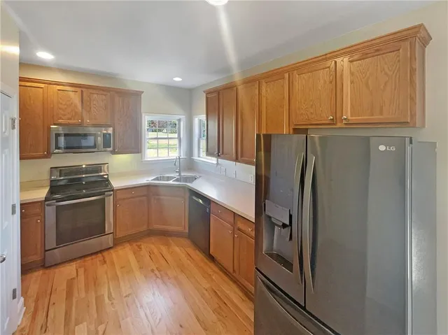 a kitchen with granite countertop a refrigerator stove and sink