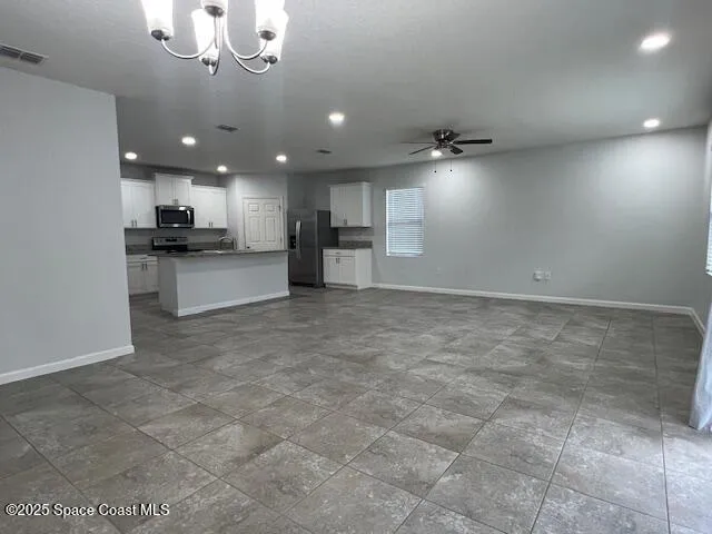 a view of a kitchen with a sink and chandelier