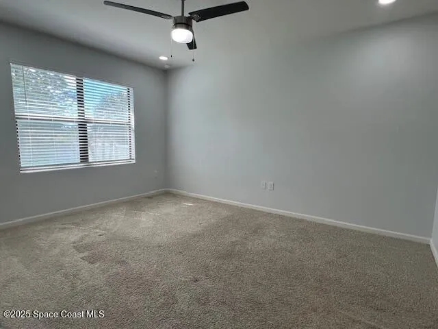 an empty room with a window and a fan