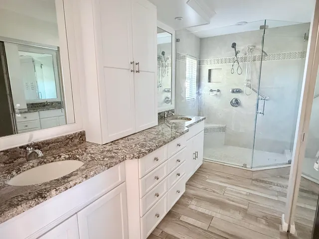 a spacious bathroom with a granite countertop sink mirror and shower