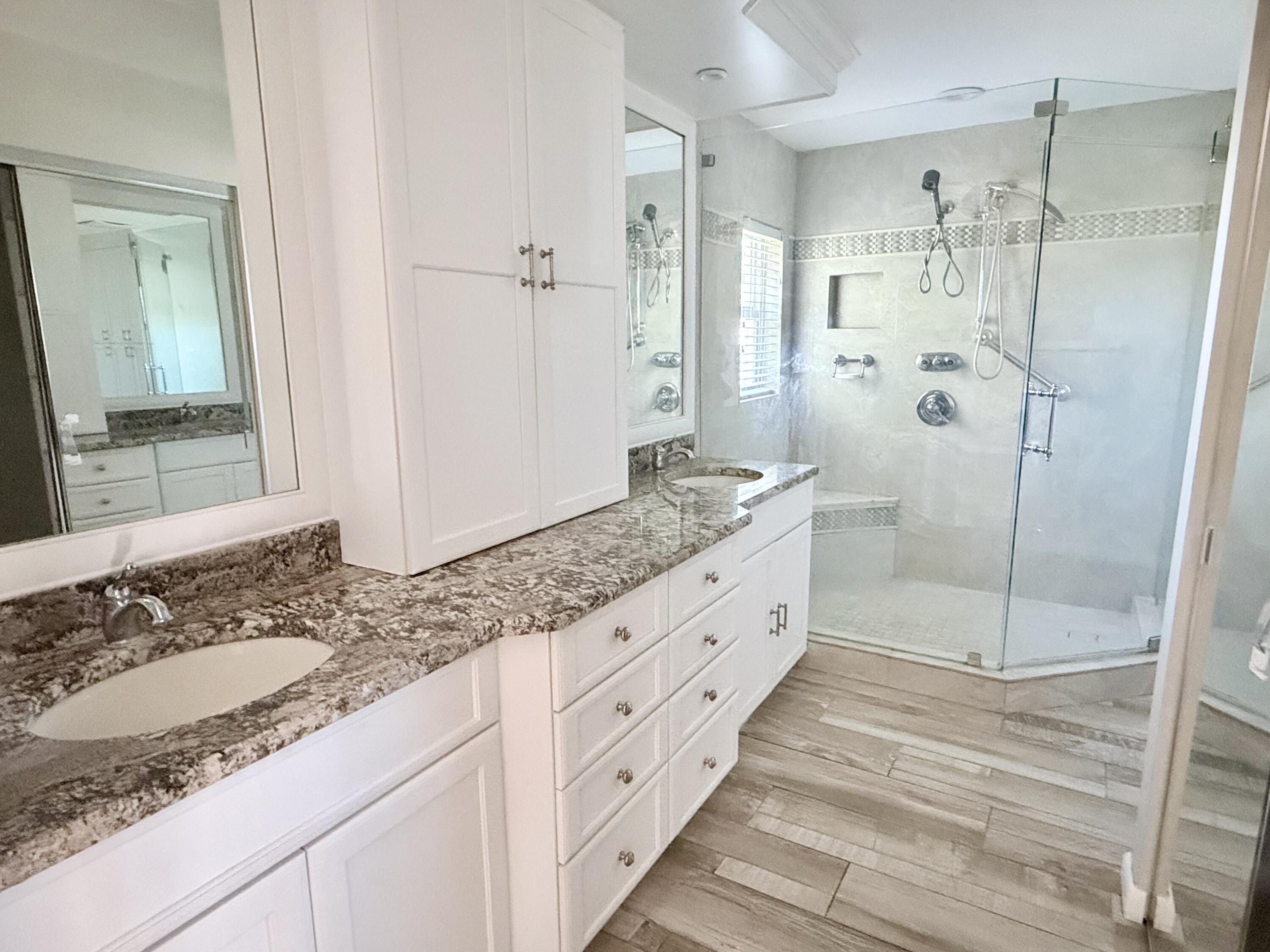 82 Sandpiper Way Boynton Beach, FL 33436 - Photo 14 of 24 a spacious bathroom with a granite countertop sink mirror and shower