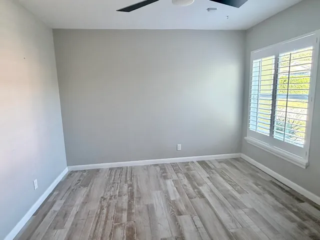 wooden floor in an empty room with a window