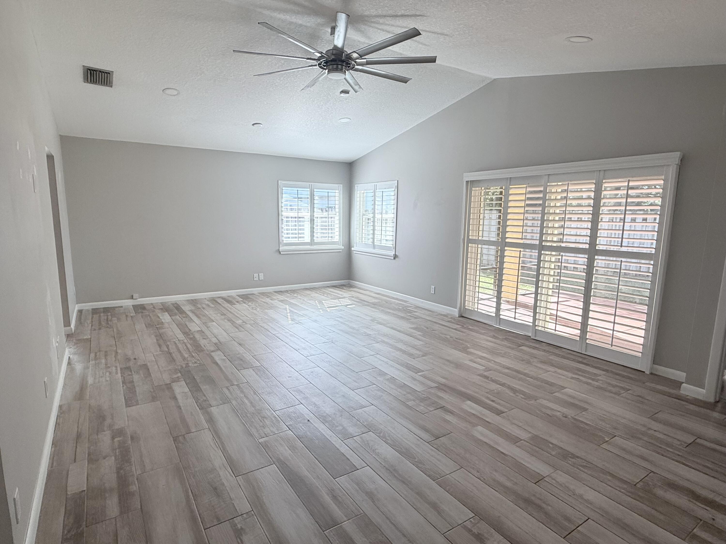 82 Sandpiper Way Boynton Beach, FL 33436 - Photo 2 of 24 a view of an empty room with wooden floor and a window
