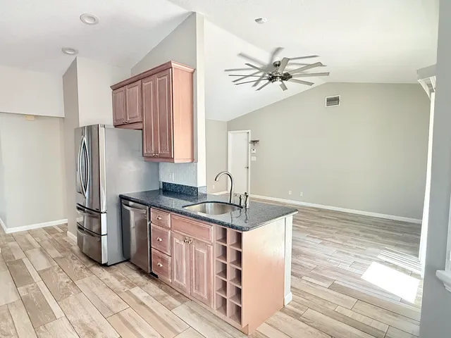 a kitchen with stainless steel appliances granite countertop a refrigerator and a sink
