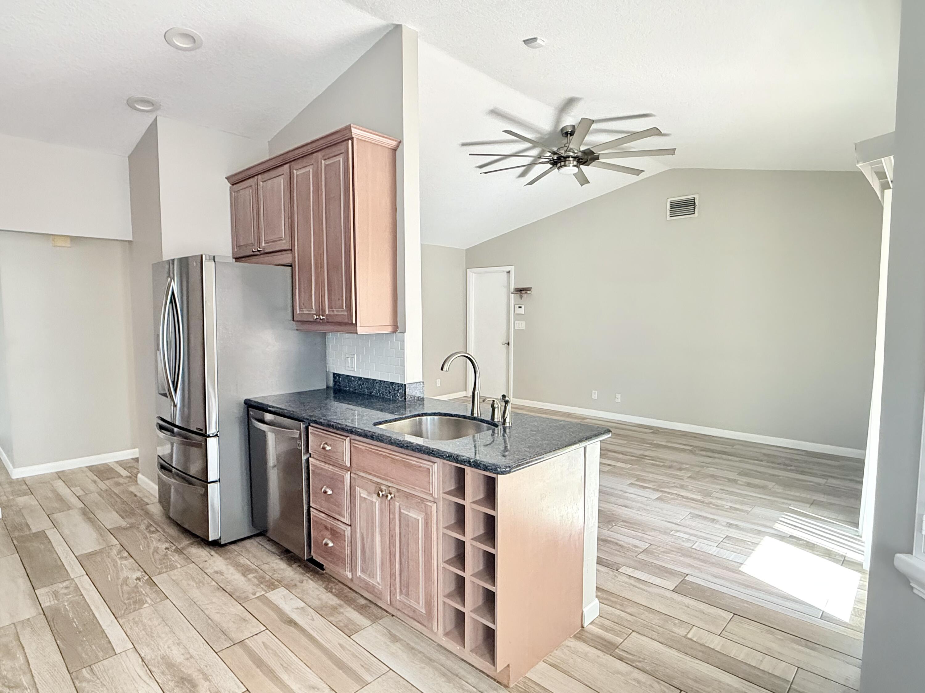 82 Sandpiper Way Boynton Beach, FL 33436 - Photo 9 of 24 a kitchen with stainless steel appliances granite countertop a refrigerator and a sink