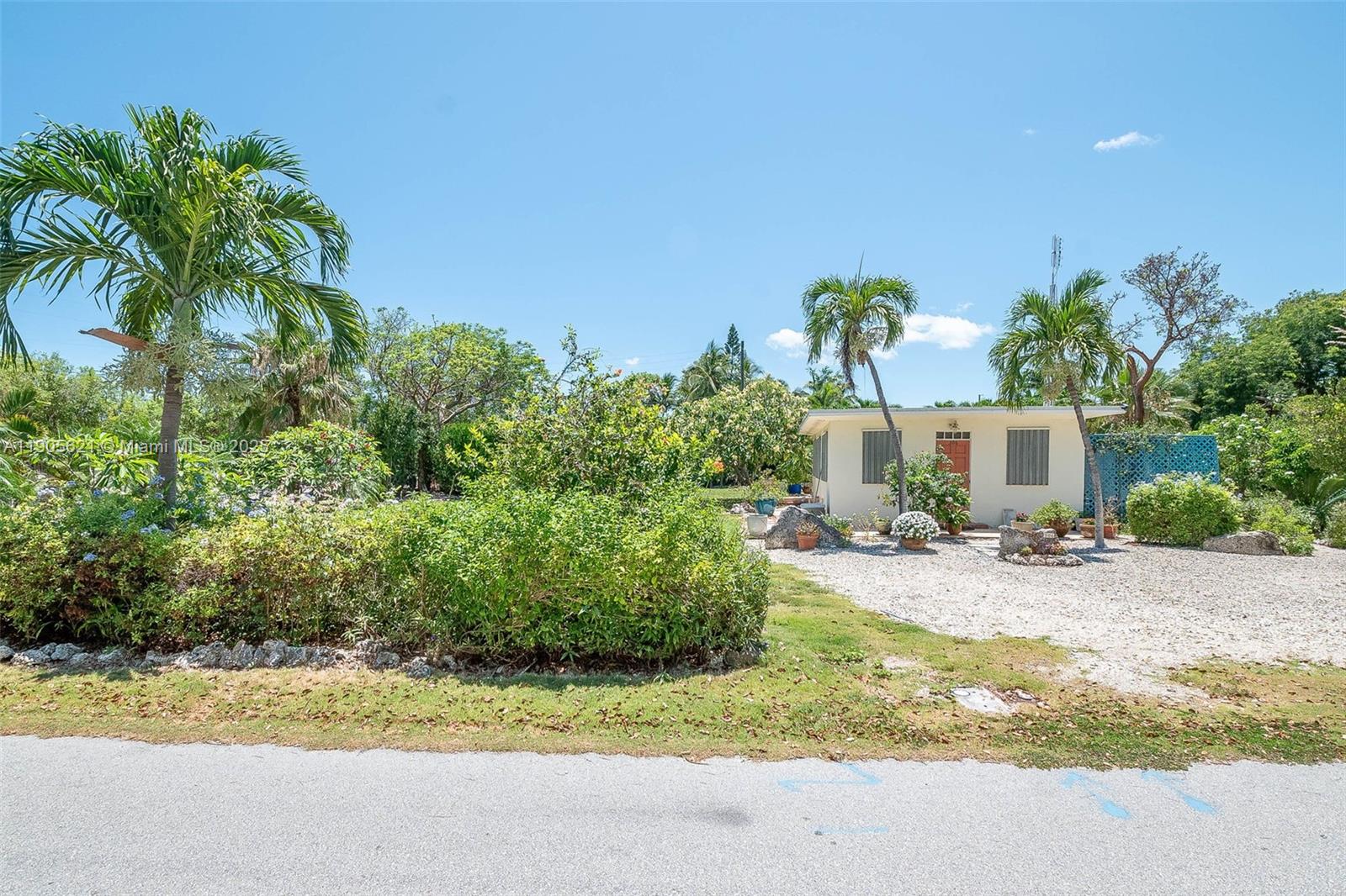 306 Lime Street Key Largo, FL 33037 - Photo 14 of 37 a front view of a house with yard and trees in the background