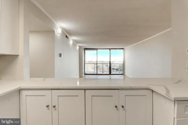 a kitchen with granite countertop white cabinets and a window