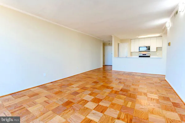 a view of empty room with wooden floor